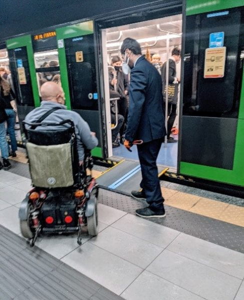Conductor laying a ramp for wheelchair users 