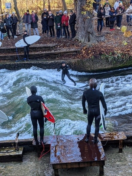Surfers surfing the Isar River from the English Garden