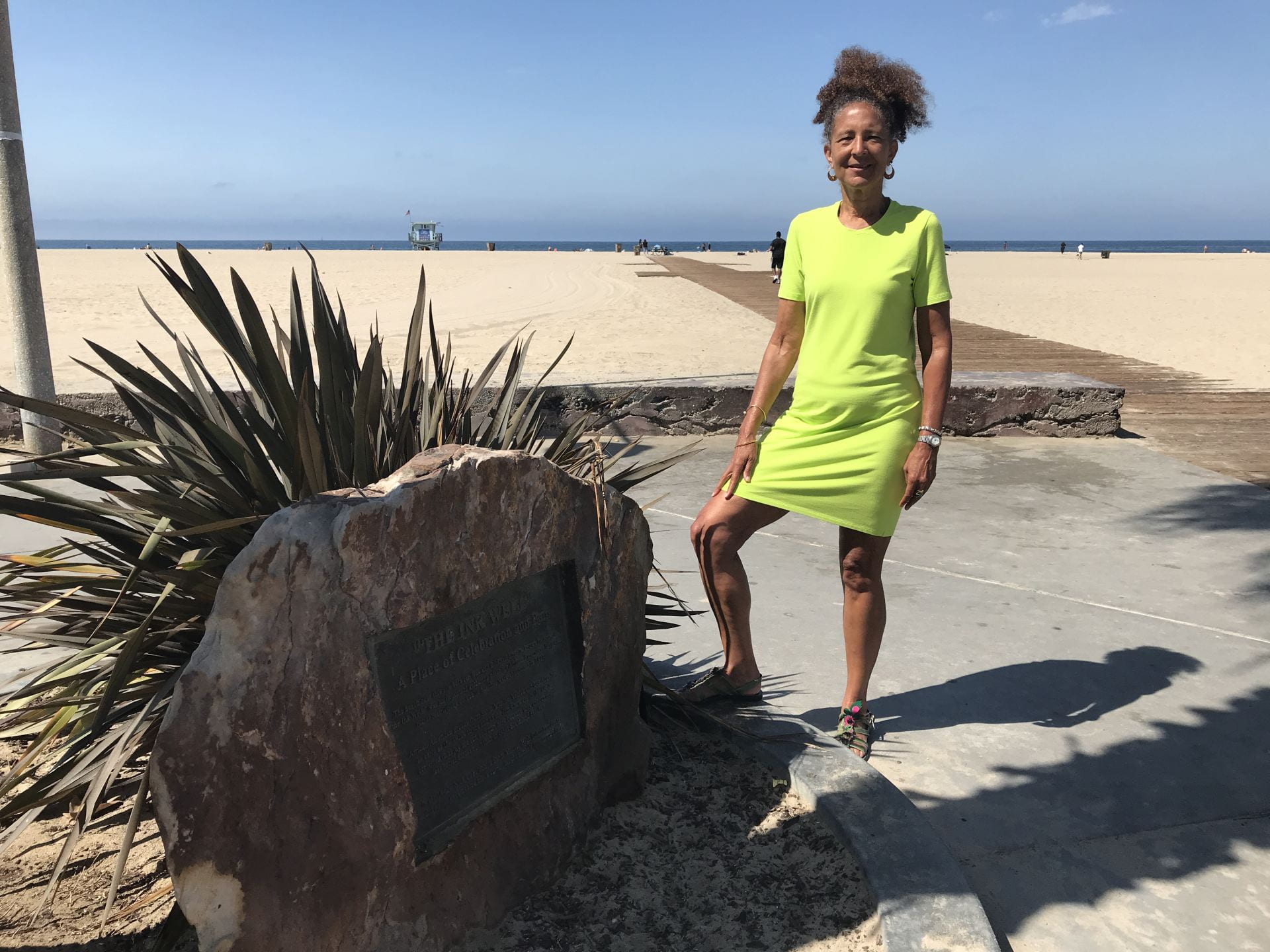 Alison Rose Jefferson next to the plaque commemorating Bay Street Beach, known derisively as "the Inkwell." The plaque is embedded into a large rock near the beach in Santa Monica.